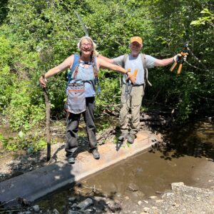 2 muddy big bitten people standing on a drainpipe